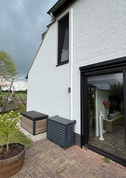 Buitenunit met antraciet Qventi cover naast terras – Oirschot.jpg